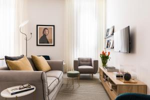 a living room with a couch and a chair at Maison Letizia Roma in Rome