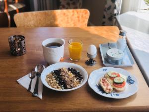 a table with two plates of breakfast food and a drink at Järnvägshotellet in Gävle