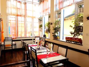 a restaurant with tables and chairs in a room with windows at Hotel le Trianon in Antsirabe