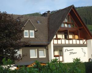 una casa con un techo con un cartel. en Pension Möser, en Lennestadt