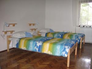 two beds with colorful sheets in a room at Guest House Rože in Ilirska Bistrica