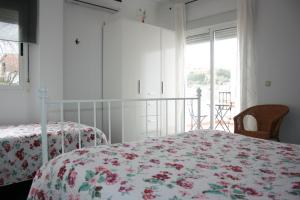 a white bedroom with two beds and a window at Mirador Tierra de Frontera in Alcalá la Real