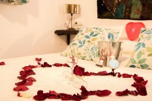una mesa con pétalos de rosa roja en una cama en Cazorla Rural, en Quesada