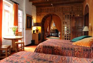 a bedroom with two beds and a table and a kitchen at Boutique Hotel Antinea in Quito