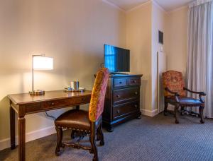 a living room with a chair and a tv at Hotel Bentley in Alexandria