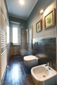 een badkamer met een wastafel, een toilet en een douche bij TORINO VACANCY 1 in Turijn