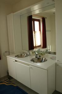 Lo-Reninge的住宿－特麗格百利酒店，一间带两个盥洗盆和大镜子的浴室