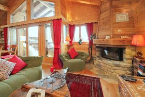 sala de estar con sofá y chimenea en Chalet El Condor, en Crans-Montana