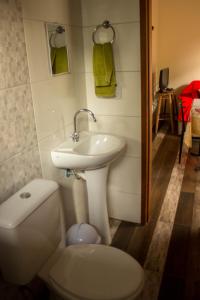 a bathroom with a white sink and a toilet at Casa tranquila perto da Joaquina in Florianópolis