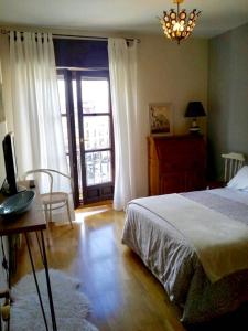 1 dormitorio con cama, mesa y ventana en Apartamento Plaza Mayor, en Zamora