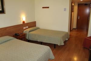 Postel nebo postele na pokoji v ubytování Hotel Flora Parc