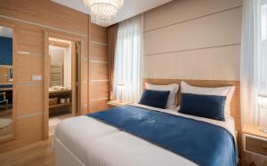 a bedroom with a large bed with blue pillows at VIP Rooms in Split