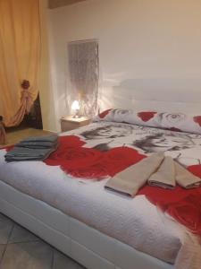 uma cama com rosas vermelhas com toalhas em Dimora Centrale em Monopoli