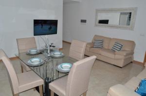 a living room with a glass table and a couch at House Gonçalves in Praia