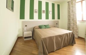 a bedroom with a bed and green and white stripes at B&B La Frola in Baldissero Torinese