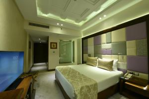 Al Masa Hotel Nasr City في القاهرة: غرفة نوم بسرير وتلفزيون بشاشة مسطحة