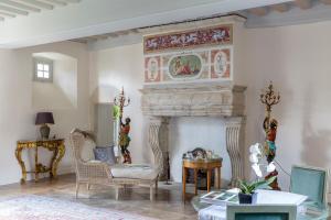 a living room with a fireplace with a painting on the wall at Le Manoir de La Fieffe in Cherbourg en Cotentin