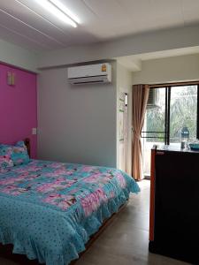 1 dormitorio con 1 cama en una habitación con ventana en Vanlisut Hotel Ngamwongwan en Nonthaburi
