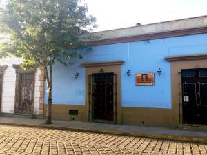 niebieski budynek z dwoma drzwiami i drzewem w obiekcie Marhialja Hotel Boutique w mieście Oaxaca