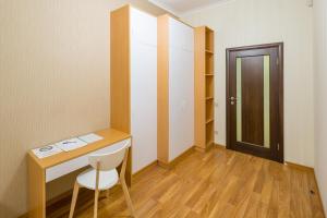 Zimmer mit einem Schreibtisch, einem Stuhl und einer Tür in der Unterkunft Apartment on Svobody Avenue 25 in Lwiw