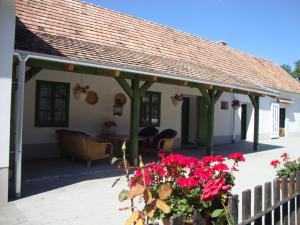 un patio avec un toit, une table et des fleurs dans l'établissement Ferienhaus Somloi Sellö, à Somlószőlős