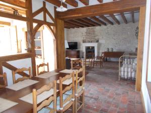 Zimmer mit Holztischen und -stühlen in einem Gebäude in der Unterkunft gite du haut du bourg in Veuil