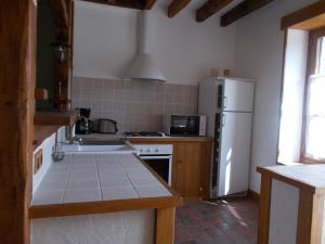 a kitchen with a white refrigerator and a sink at gite du haut du bourg in Veuil