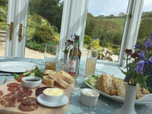 a table with a plate of food and a bottle of beer at Polraen Country House Hotel in Looe +43 photos
