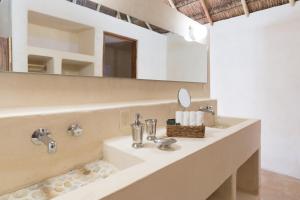 a bathroom with two sinks and a mirror at Hotel CasaBakal - A pie de Laguna - Bacalar in Bacalar