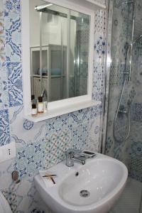 y baño con lavabo, espejo y ducha. en "A Livanti" B&B, en Marzamemi