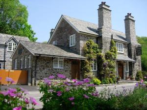 une maison en pierre avec des fleurs devant elle dans l'établissement Polraen Country House Hotel, à Looe