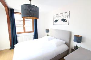 a bedroom with a white bed and a window at Au Bonheur des Anges Appartement 2 chambres avec terrasse in Colmar