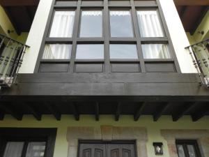 una gran ventana en el lateral de una casa en Apartamentos Turísticos Las Nieves, en Póo