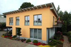 een geel huis met een balkon en bloemen bij Auf dem Blumenhof in Heringsdorf