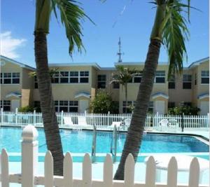 two palm trees in front of a building with a pool at Barefoot Beach Resort in Clearwater Beach