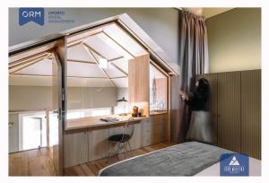 una persona parada en un dormitorio con una cama y una ventana en ORM - Almada Terrace Apartment, en Oporto