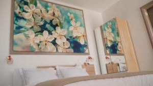 a bedroom with two pictures of flowers on the wall at Olive House Apartments in Kavála