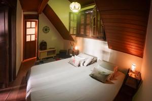a bedroom with a large white bed with two pillows at Casa da Estacao - A casa mais charmosa de Morretes! in Morretes