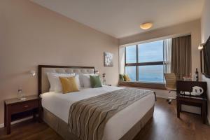 um quarto de hotel com uma cama grande e uma janela em Haifa Bay View Hotel By AFI Hotels em Haifa