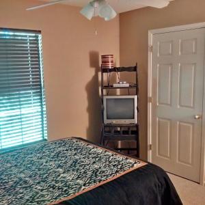 Heber Springs的住宿－Greers Ferry Lake Cabin，一间卧室设有一张床、一台电视和一个窗口。