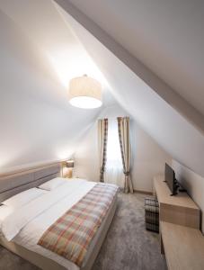モロエニにあるChalet Alpinaの白いベッドルーム(ベッド1台、窓付)