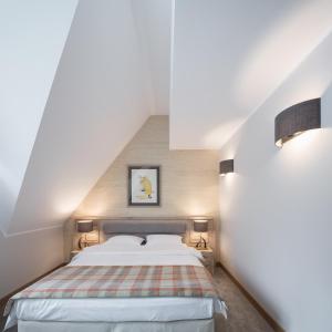 a bedroom with a bed in a attic with two lamps at Chalet Alpina in Moroeni