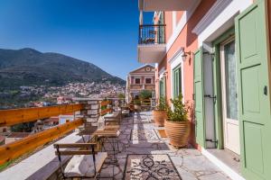 a balcony with chairs and a view of a city at Symi Nautilus Luxury Suites in Symi