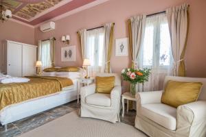 een slaapkamer met een bed en 2 stoelen bij Symi Nautilus Luxury Suites in Symi
