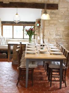 une grande table en bois avec des chaises et un vase de fleurs dans l'établissement Midford Mill, à Bath