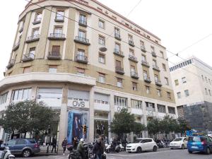 a large building on a busy city street with cars at Loft by B&B Università in Naples