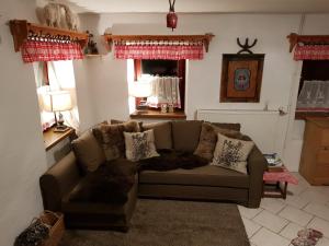 Zajček Apartma في موجسترانا: غرفة معيشة مع أريكة بنية ونافذة