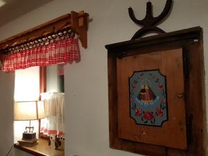 um armário de madeira num quarto com um candeeiro e uma janela em Zajček Apartma em Mojstrana