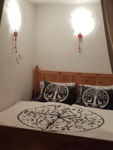 a bed with two pillows and two lights on the wall at Zajček Apartma in Mojstrana