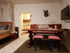 - un salon avec une table et deux tabourets dans l'établissement Zajček Apartma, à Mojstrana
